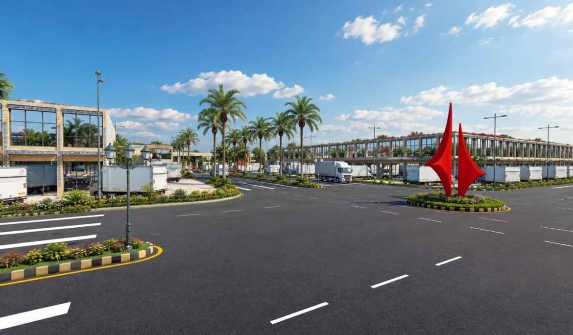 Industrial complex roundabout with red sculptural landmark and palm-lined road