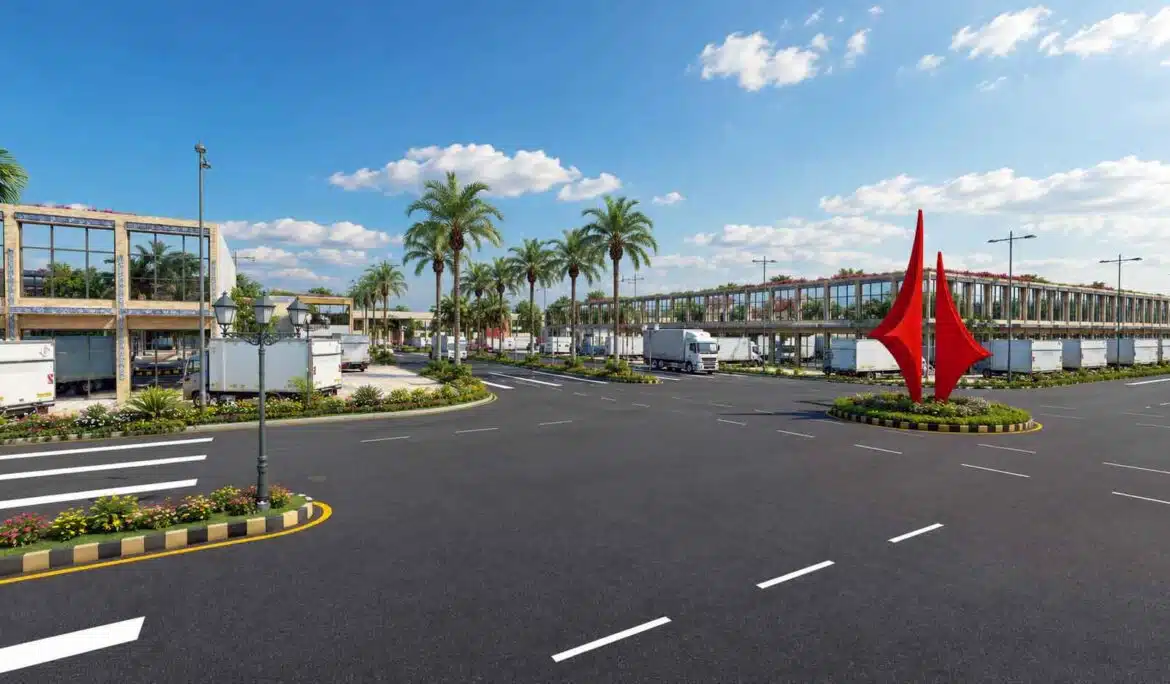 Industrial complex roundabout with red sculptural landmark and palm-lined road