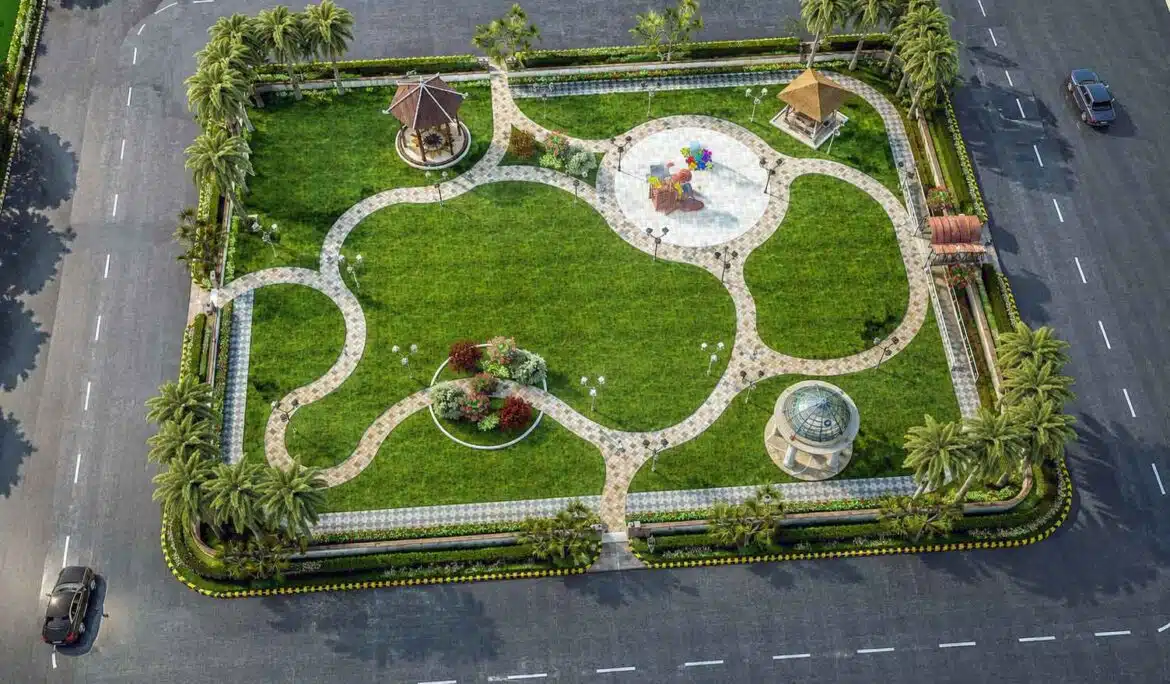Aerial daytime view of a rectangular community park with curved pathways, two gazebos, a central play area, and palm trees along the boundary.